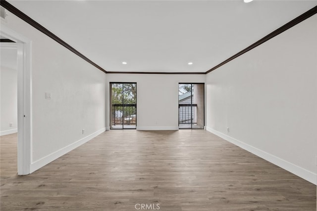 spare room with ornamental molding and light wood-type flooring