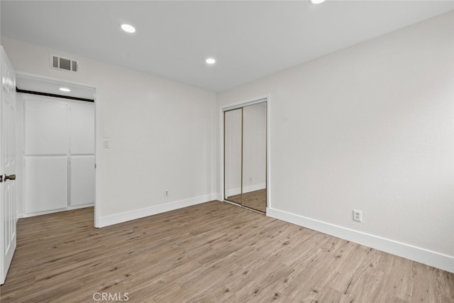 unfurnished bedroom featuring a closet and light hardwood / wood-style flooring