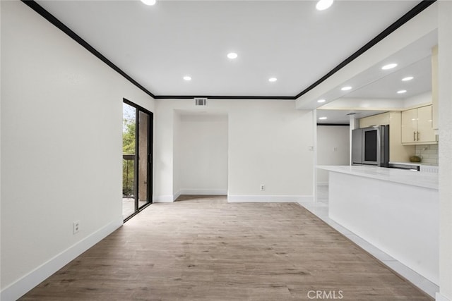 unfurnished living room featuring crown molding and light wood-type flooring