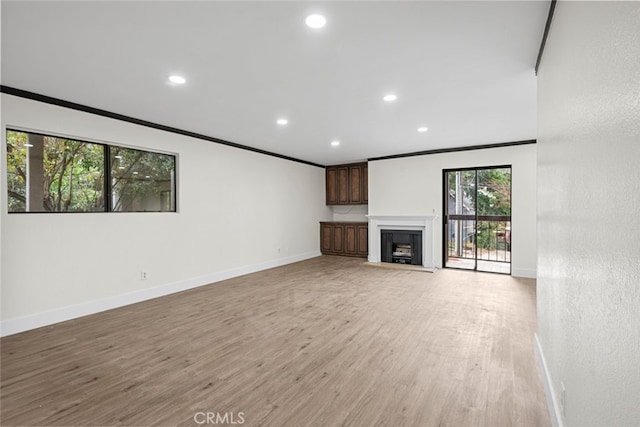 unfurnished living room with ornamental molding and light hardwood / wood-style flooring