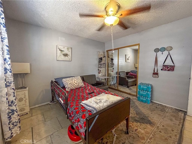 bedroom with ceiling fan, a textured ceiling, and a closet