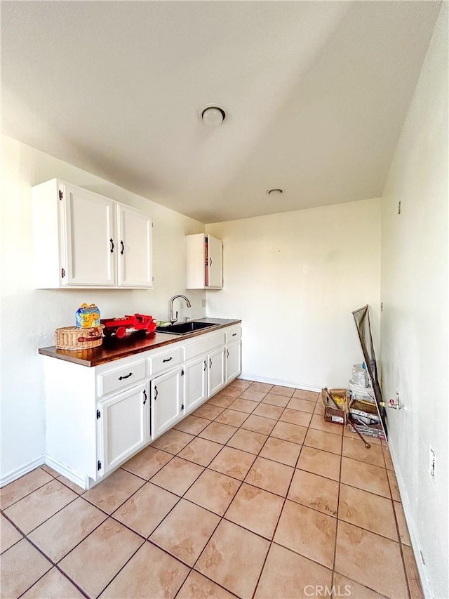 kitchen featuring white cabinetry, sink, and light tile patterned floors