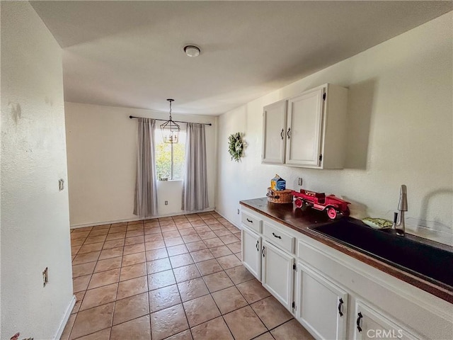 kitchen with white cabinetry, sink, pendant lighting, and light tile patterned floors