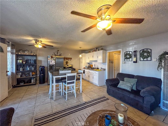 dining room featuring ceiling fan, sink, and a textured ceiling