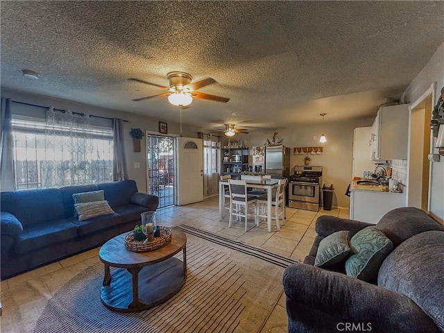 living room with ceiling fan and a textured ceiling