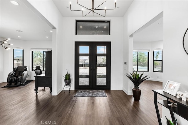 foyer entrance featuring french doors, dark hardwood / wood-style flooring, and a notable chandelier