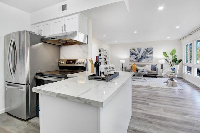 kitchen with white cabinetry, tasteful backsplash, light stone counters, light hardwood / wood-style flooring, and appliances with stainless steel finishes