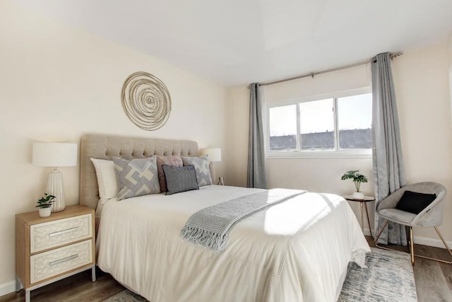 bedroom with dark hardwood / wood-style flooring