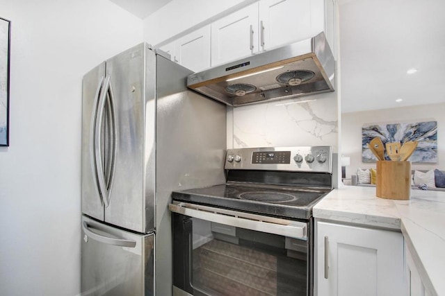 kitchen with appliances with stainless steel finishes, white cabinets, light stone counters, and decorative backsplash