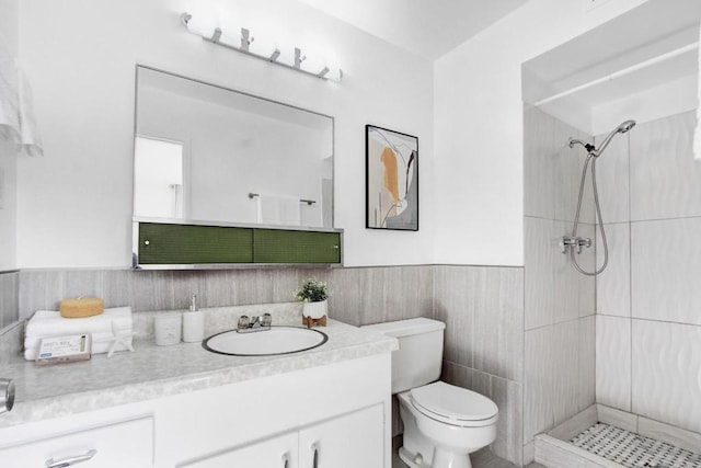 bathroom featuring vanity, toilet, and a tile shower