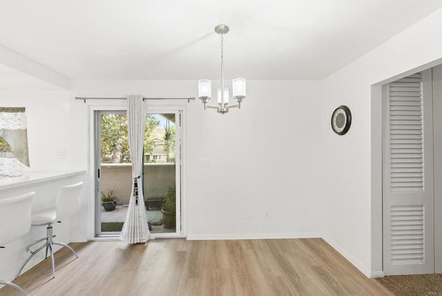 unfurnished dining area featuring wood-type flooring and a chandelier