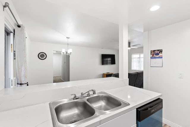 kitchen featuring decorative light fixtures, dishwasher, sink, light stone counters, and ceiling fan