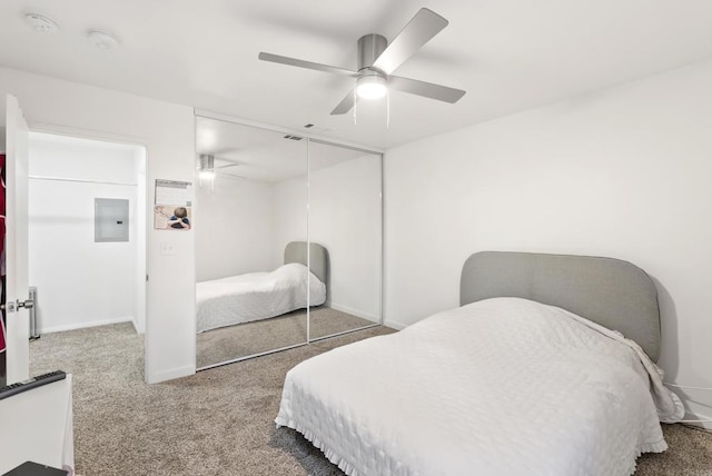 carpeted bedroom with electric panel, a closet, and ceiling fan