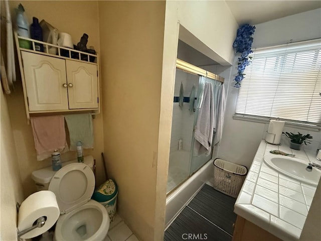 full bathroom with vanity, shower / bath combination with glass door, and toilet