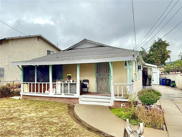 bungalow-style home with a garage, a porch, and a front yard