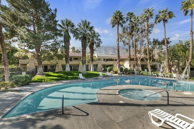 view of pool with a mountain view, a yard, and a community hot tub