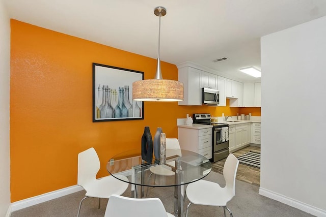 carpeted dining space featuring sink