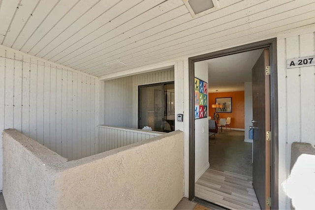 interior space featuring wood ceiling and wood walls