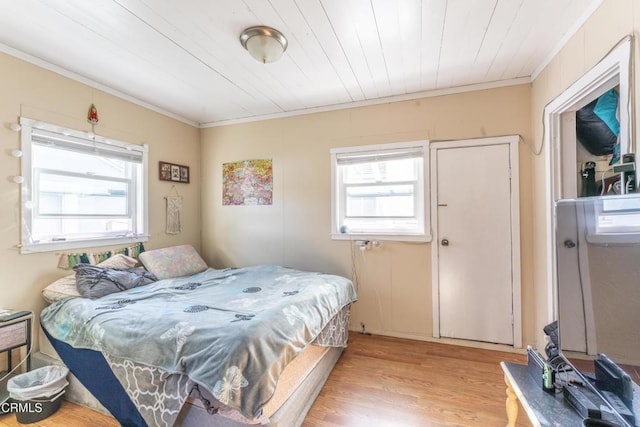 bedroom with ornamental molding and light hardwood / wood-style flooring