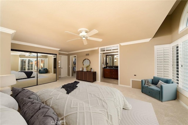 bedroom with crown molding, light carpet, ceiling fan, and ensuite bath