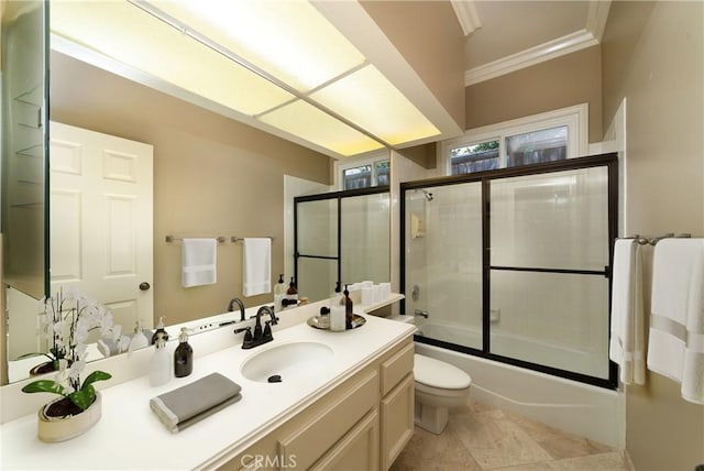 full bathroom with vanity, ornamental molding, toilet, and combined bath / shower with glass door