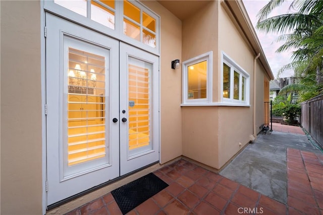 exterior entry at dusk featuring a patio area and french doors