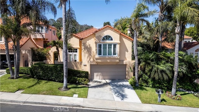 mediterranean / spanish-style house featuring a garage and a front yard