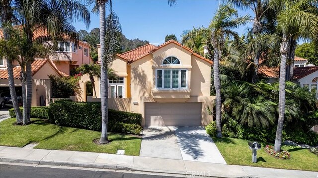 12999 Caminito Pointe Del Mar, Del Mar, CA 92014 - mediterranean / spanish-style house with driveway, a tile roof, an attached garage, stucco siding, and a front lawn