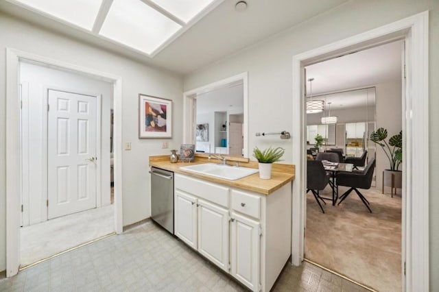 kitchen with sink, stainless steel dishwasher, and white cabinets