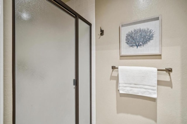 bathroom featuring a shower with door