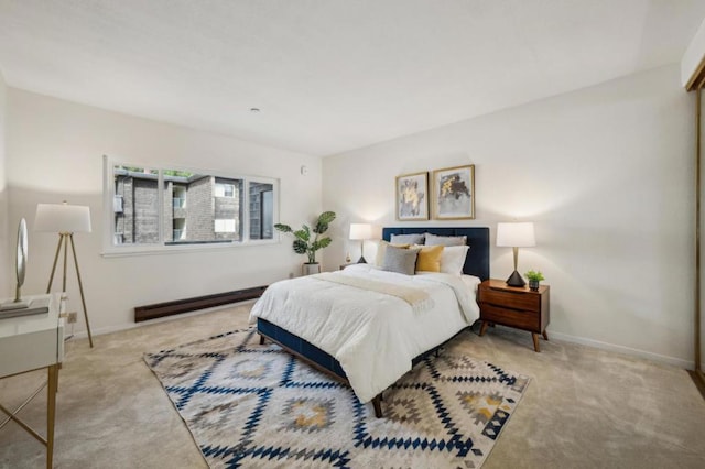 bedroom with a baseboard radiator and light carpet