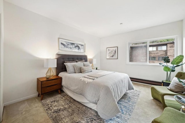 bedroom with light carpet and a baseboard heating unit