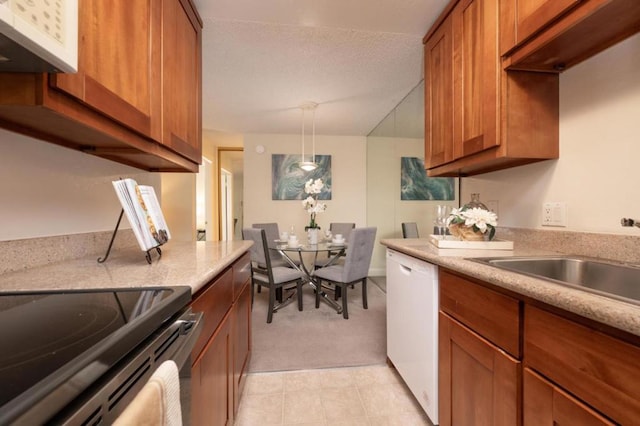 kitchen with sink, dishwasher, range with electric stovetop, light stone countertops, and decorative light fixtures