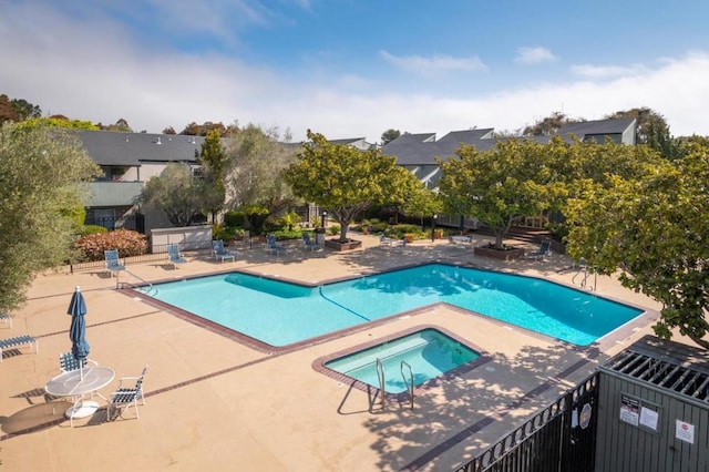 view of swimming pool with a hot tub and a patio