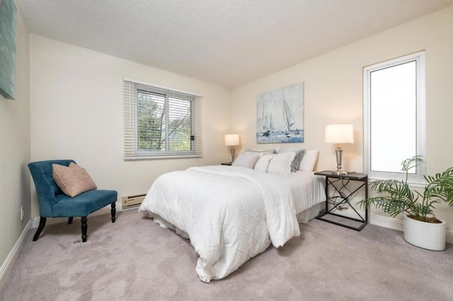 carpeted bedroom with a textured ceiling, multiple windows, and a baseboard heating unit