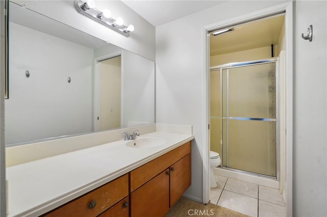 bathroom with vanity, a shower with shower door, tile patterned floors, and toilet