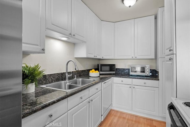 kitchen featuring white cabinetry, sink, white appliances, and light hardwood / wood-style flooring