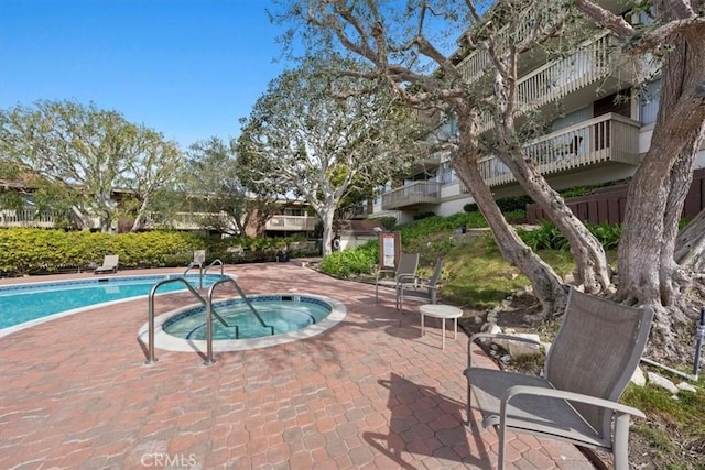 view of pool with a community hot tub and a patio