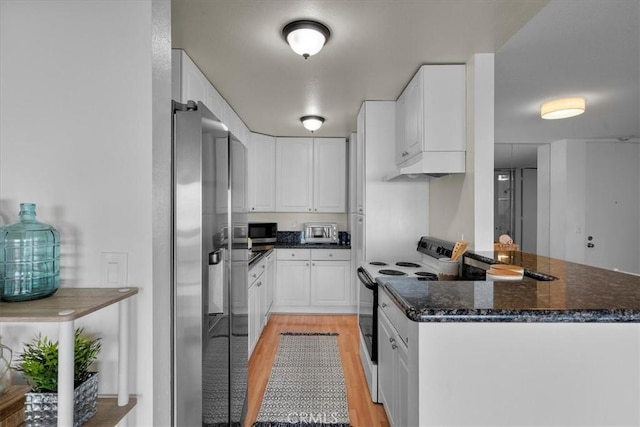 kitchen featuring dark stone countertops, white cabinets, electric range, stainless steel fridge with ice dispenser, and light wood-type flooring