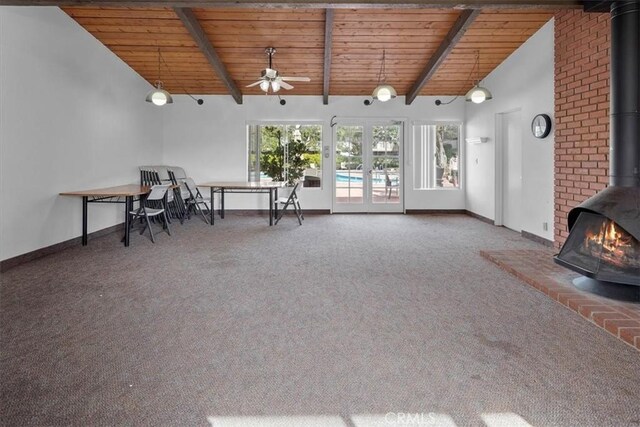 interior space featuring carpet floors, a wood stove, wooden ceiling, and beam ceiling