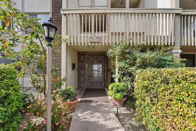 view of exterior entry featuring a balcony