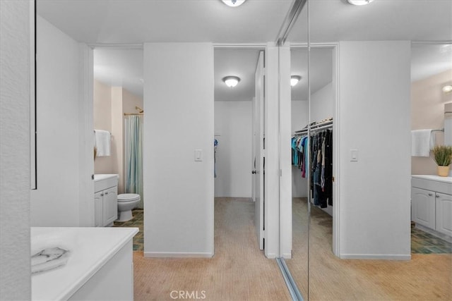 bathroom with vanity, hardwood / wood-style floors, toilet, and walk in shower