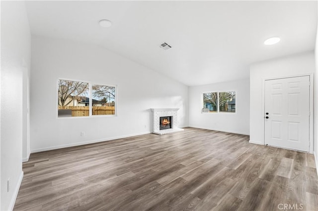 unfurnished living room with a fireplace, hardwood / wood-style flooring, and vaulted ceiling