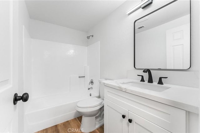 full bathroom featuring shower / washtub combination, hardwood / wood-style floors, vanity, and toilet