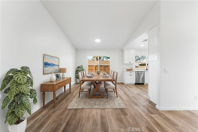 dining space with lofted ceiling and light wood-type flooring