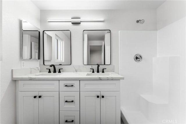 bathroom with walk in shower and vanity