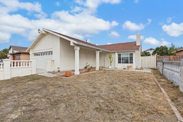 rear view of house with a garage and a yard