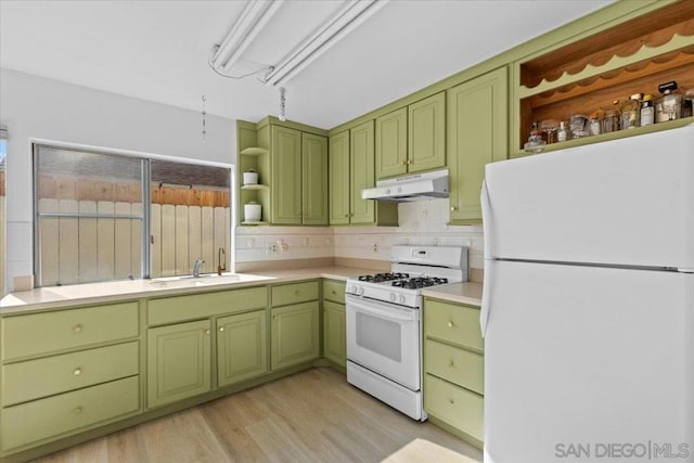 kitchen with sink, white appliances, backsplash, light hardwood / wood-style floors, and green cabinetry