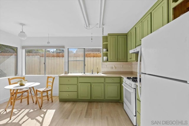 kitchen with sink, white appliances, backsplash, light hardwood / wood-style floors, and green cabinetry