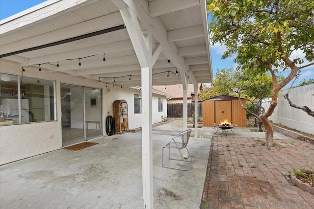 view of patio featuring a storage shed and a fire pit